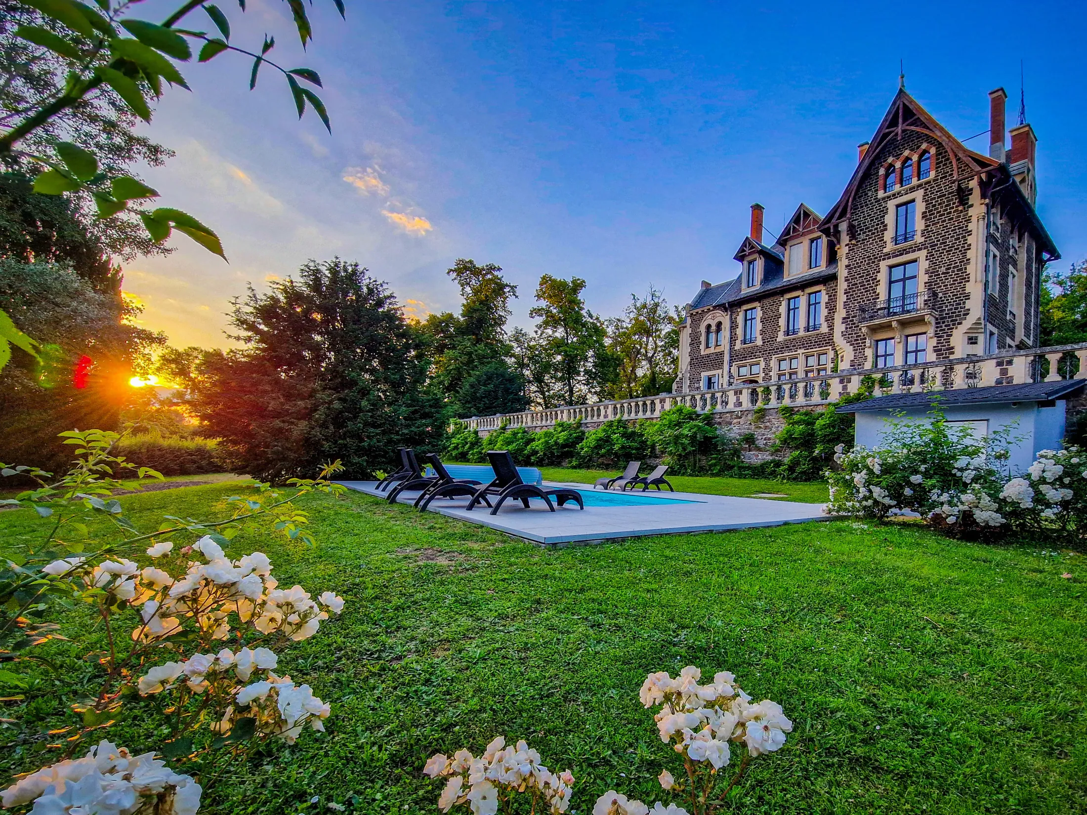 Le Manoir des Rêves Sauvages au coucher du soleil, sa piscine et son parc